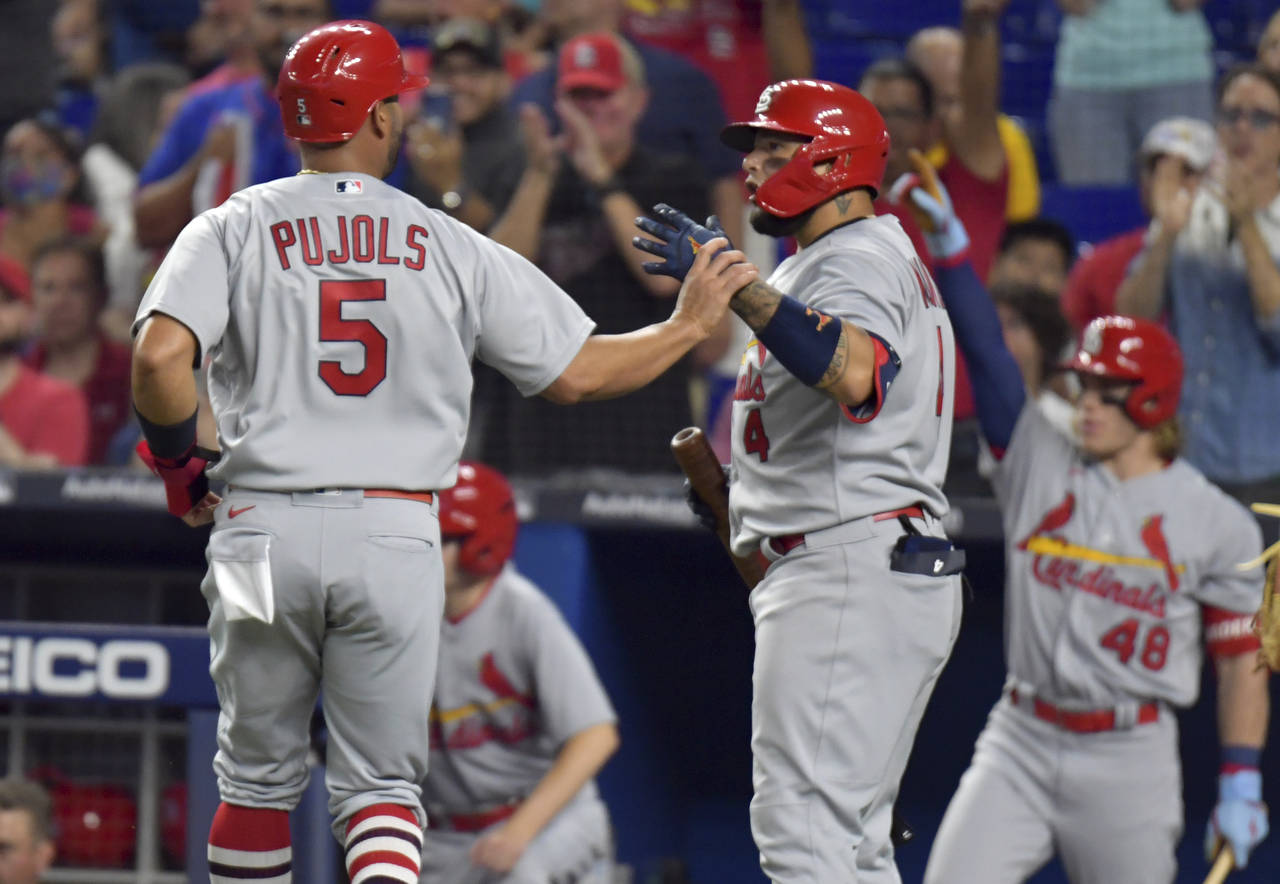 St. Louis Cardinals' Albert Pujols (5) is greeted by Yadier Molina after scoring during the second ...