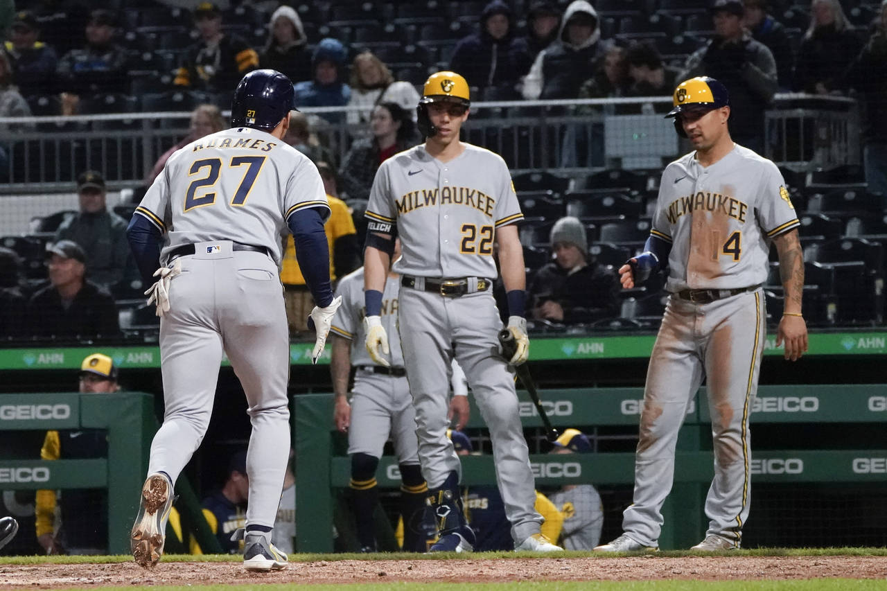 Milwaukee Brewers' Jace Peterson (14) and Christian Yelich (22) await Willy Adames after he hit a t...