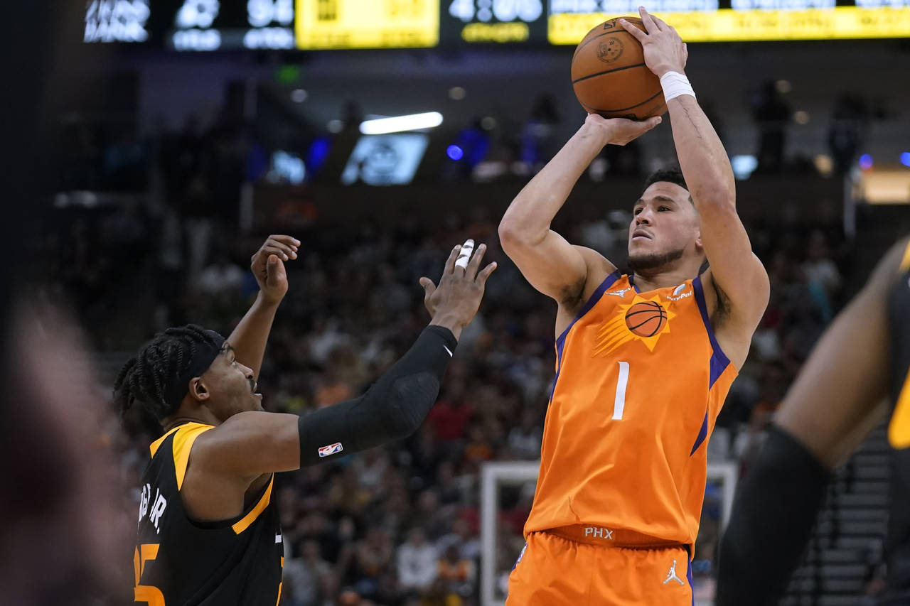 Phoenix Suns guard Devin Booker (1) shoots as Utah Jazz forward Danuel House Jr. (25) defends durin...