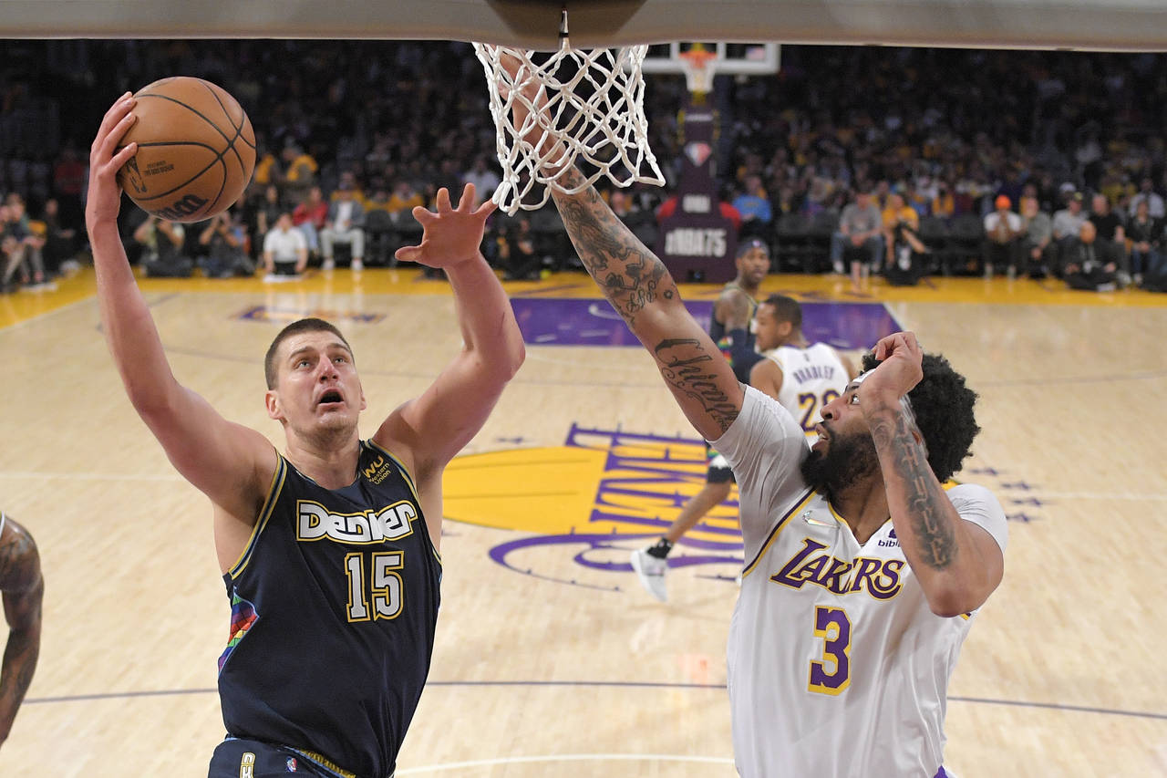Denver Nuggets center Nikola Jokic, left, shoots as Los Angeles Lakers forward Anthony Davis defend...