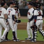 
              Atlanta Braves pitcher Kyle Wright, second from left, meets with manager Brian Snitker, second from right, during the sixth inning of the team's baseball game against the Miami Marlins on Friday, April 22, 2022, in Atlanta. (AP Photo/Ben Margot)
            