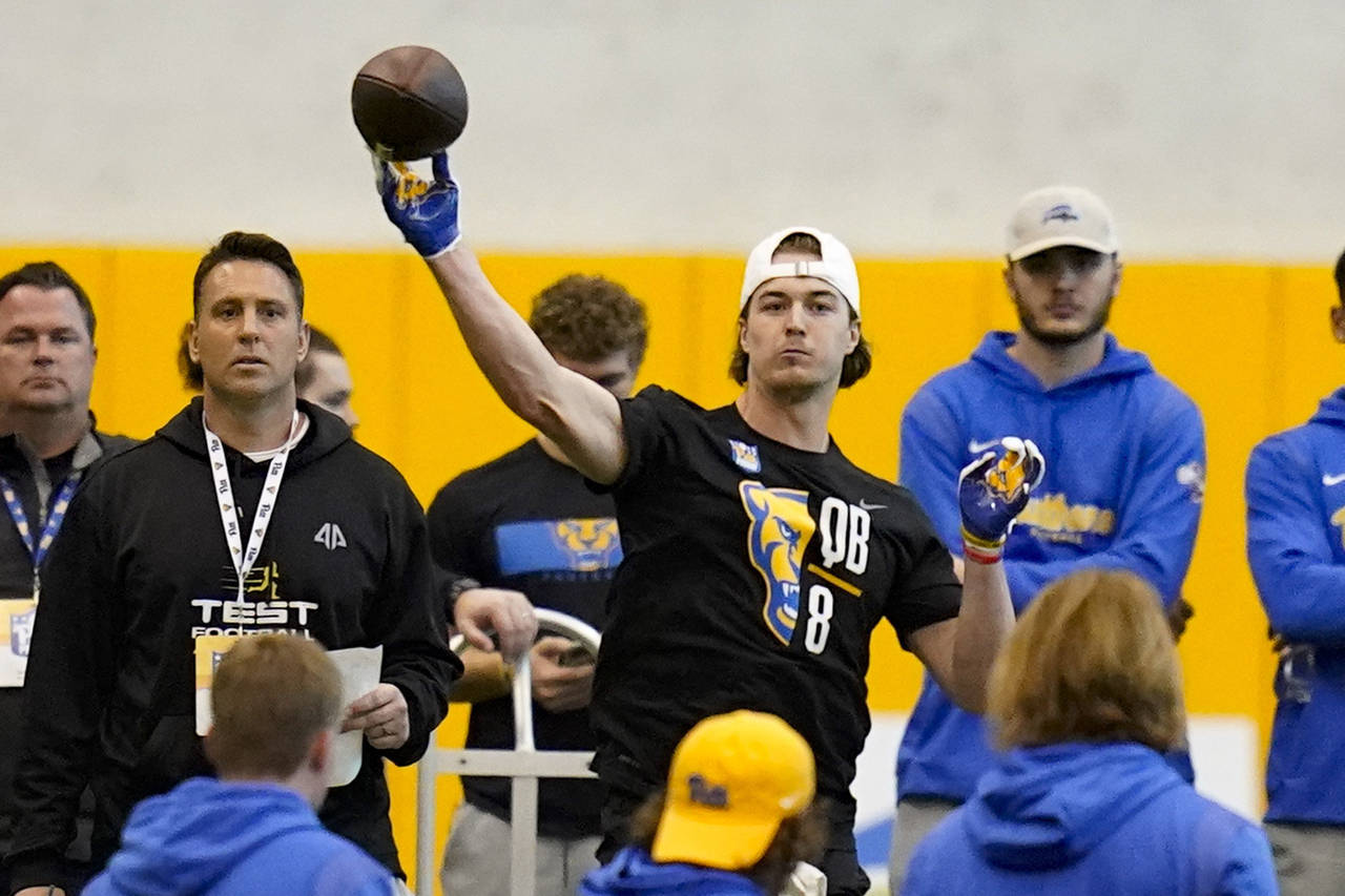 FILE - Quarterback Kenny Pickett (8) goes through passing drills during Pittsburgh's football pro d...
