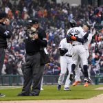 
              Detroit Tigers greet Javier Baez, right, after hitting a walk-off single during the ninth inning of a baseball game against the Chicago White Sox, Friday, April 8, 2022, in Detroit. The umpires were ruling on the play which was initially called an out. (AP Photo/Carlos Osorio)
            