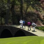 
              Tiger Woods walks across the Ben Hogan Bridge with Joaquin Niemann, of Chile, during the first round at the Masters golf tournament on Thursday, April 7, 2022, in Augusta, Ga. (AP Photo/David J. Phillip)
            