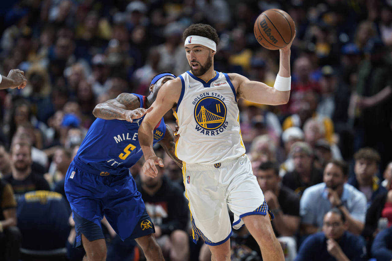 Golden State Warriors guard Klay Thompson, front, fields a pass as Denver Nuggets forward Will Bart...