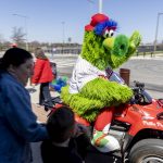 
              The Phillie Phanatic drives past fans outside the ball park before the start of the Philadelphia Phillies home opening baseball game against the Oakland Athletics, Friday, April 8, 2022, in Philadelphia. (AP Photo/Laurence Kesterson)
            