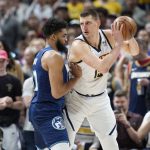 
              Denver Nuggets center Nikola Jokic, right, looks to drive to the basket as Minnesota Timberwolves center Karl-Anthony Towns defends in the first half of an NBA basketball game Friday, April 1, 2022, in Denver. (AP Photo/David Zalubowski)
            