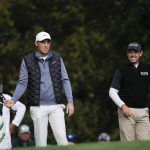 
              Scottie Scheffler, left, and Charl Schwartzel, of South Africa, wait to tee off on the 11th hole during the third round at the Masters golf tournament on Saturday, April 9, 2022, in Augusta, Ga. (AP Photo/Jae C. Hong)
            