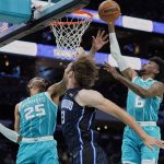 
              Charlotte Hornets forwards P.J. Washington, left, and Jalen McDaniels, right rebound over Orlando Magic center Robin Lopez, center, during the first half of an NBA basketball game on Thursday, April 7, 2022, in Charlotte, N.C. (AP Photo/Rusty Jones)
            