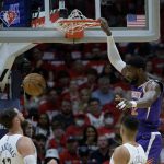 
              Phoenix Suns center Deandre Ayton (22) dunks against New Orleans Pelicans guard CJ McCollum in the first half of Game 4 of an NBA basketball first-round playoff series in New Orleans, Sunday, April 24, 2022. (AP Photo/Matthew Hinton)
            