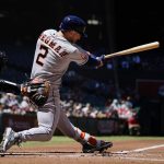 
              Houston Astros' Alex Bregman (2) hits an infield grounder as Arizona Diamondbacks catcher Carson Kelly, left, looks on during the first inning of a baseball game Wednesday, April 13, 2022, in Phoenix. (AP Photo/Ross D. Franklin)
            