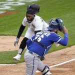 
              Chicago White Sox's Josh Harrison scores behind Kansas City Royals catcher Cam Gallagher off AJ Pollock's sacrifice fly during the eighth inning of a baseball game, Thursday, April 28, 2022, in Chicago. (AP Photo/Charles Rex Arbogast)
            