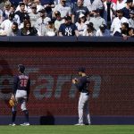 
              Cleveland Guardians' Myles Straw (7) climbs the left field wall to talk with a fan during the ninth inning of a baseball game against the New York Yankees Saturday, April 23, 2022, in New York. The Yankees won 5-4. (AP Photo/Frank Franklin II)
            