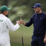 
              Scottie Scheffler pumps fists with his caddie Ted Scott after putting in on the 18th green during the second round at the Masters golf tournament on Friday, April 8, 2022, in Augusta, Ga. (AP Photo/Matt Slocum)
            