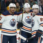 
              Edmonton Oilers' Leon Draisaitl (29) is congratulated by Evander Kane (91) and Ryan Nugent-Hopkins (93) after Draisaitl scored a goal against the Nashville Predators in the first period of an NHL hockey game Thursday, April 14, 2022, in Nashville, Tenn. (AP Photo/Mark Humphrey)
            