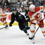 
              Calgary Flames center Trevor Lewis (22) moves the puck as San Jose Sharks left wing Alexander Barabanov (94) defends during the first period of an NHL hockey game in San Jose, Calif., Thursday, April 7, 2022. (AP Photo/Josie Lepe)
            