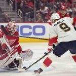 
              Detroit Red Wings goaltender Alex Nedeljkovic (39) deflects a shot by Florida Panthers center Sam Bennett (9) during the first period of an NHL hockey game, Sunday, April 17, 2022, in Detroit. (AP Photo/Carlos Osorio)
            