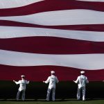 
              United States Navy sailors carry a U.S. flag during Opening Day celebrations before the San Diego Padres play the Atlanta Braves in a baseball game Thursday, April 14, 2022, in San Diego. (AP Photo/Gregory Bull)
            