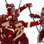 
              Denver's Cameron Wright (16) celebrates his goal with Mike Benning (20), Shai Buium (26), and Carter Mazur (34) during the third period of an NCAA men's Frozen Four semifinal hockey game against Michigan, Thursday, April 7, 2022, in Boston. (AP Photo/Michael Dwyer)
            