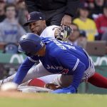 
              Toronto Blue Jays' Lourdes Gurriel Jr., front, is tagged out at third base by Boston Red Sox's Xander Bogaerts, back, in the eighth inning of a baseball game, Thursday, April 21, 2022, in Boston. (AP Photo/Steven Senne)
            