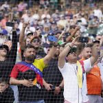 
              Venezuelan baseball fans cheer for Detroit Tigers designated hitter Miguel Cabrera as he is interviewed after the ninth inning of the first baseball game of a doubleheader against the Colorado Rockies, Saturday, April 23, 2022, in Detroit. (AP Photo/Carlos Osorio)
            