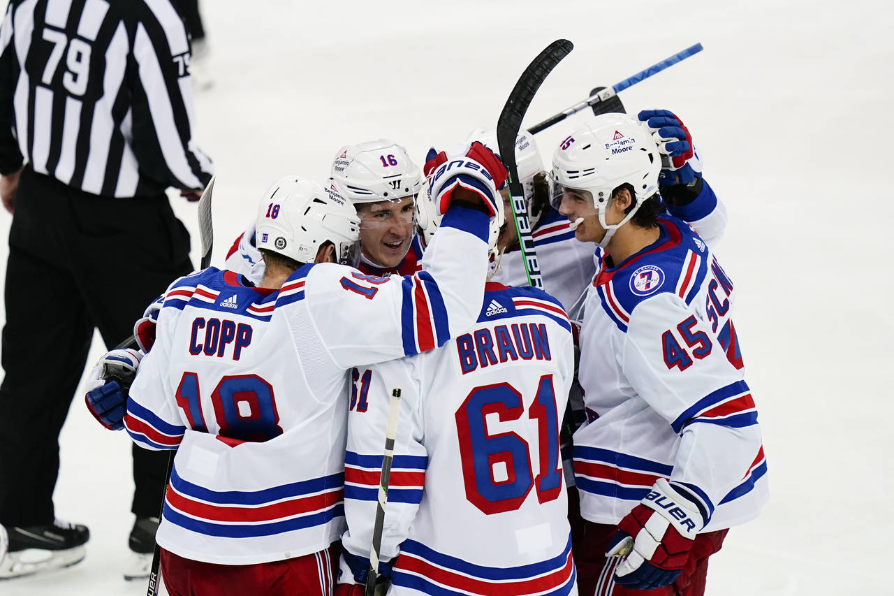 New York Rangers' Justin Braun (61) celebrates with teammates after scoring a goal during the third...