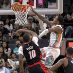 
              San Antonio Spurs guard Lonnie Walker IV (1) dunks over Portland Trail Blazers forward Reggie Perry (10) during the first half of an NBA basketball game Friday, April 1, 2022, in San Antonio. (AP Photo/Nick Wagner)
            