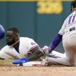 
              Texas Rangers' Adolis Garcia (53) is caught stealing second base against Colorado Rockies shortstop Jose Iglesias (11) during the eighth inning of a baseball ball game in Arlington, Texas, Monday, April 11, 2022. The Rockies won 6-4. (AP Photo/LM Otero)
            