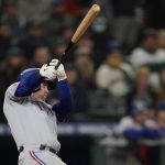 Texas Rangers' Kole Calhoun follows through on an RBI double during the ninth inning of the team's baseball game against the Seattle Mariners, Thursday, April 21, 2022, in Seattle. (AP Photo/Ted S. Warren)