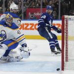 
              Buffalo Sabres goaltender Craig Anderson (41) and Toronto Maple Leafs forward Michael Bunting (58) watch as the puck hits the post during the second period of an NHL hockey game Tuesday, April 12, 2022, in Toronto. (Nathan Denette/The Canadian Press via AP)
            