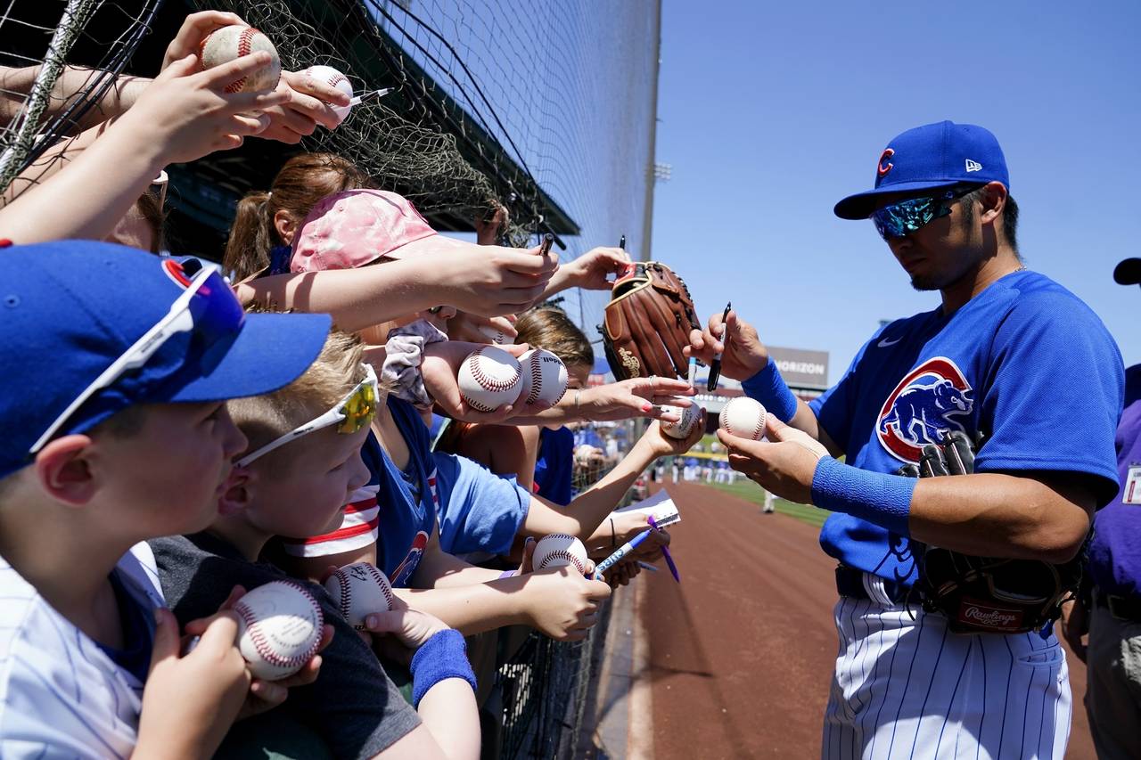FILE - Chicago Cubs' Seiya Suzuki, of Japan, signs autographs for fans prior to a spring training b...