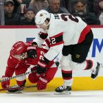
              Detroit Red Wings center Mitchell Stephens, left, and is held by Ottawa Senators defenseman Nikita Zaitsev (22) in the second period of an NHL hockey game Tuesday, April 12, 2022, in Detroit. (AP Photo/Paul Sancya)
            