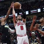 
              Chicago Bulls guard Zach LaVine (8) drives to the basket against Milwaukee Bucks guard Jevon Carter, left, and forward Giannis Antetokounmpo during the first half of Game 3 of a first-round NBA basketball playoff series Friday, April 22, 2022, in Chicago. (AP Photo/Nam Y. Huh)
            