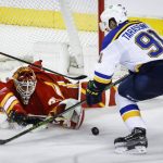 
              St. Louis Blues' Vladimir Tarasenko, right, tries to get to the puck as Calgary Flames goalie Jacob Markstrom, center scrambles for it during the third period of an NHL hockey game Saturday, April 2, 2022, in Calgary, Alberta. (Jeff McIntosh/The Canadian Press via AP)
            