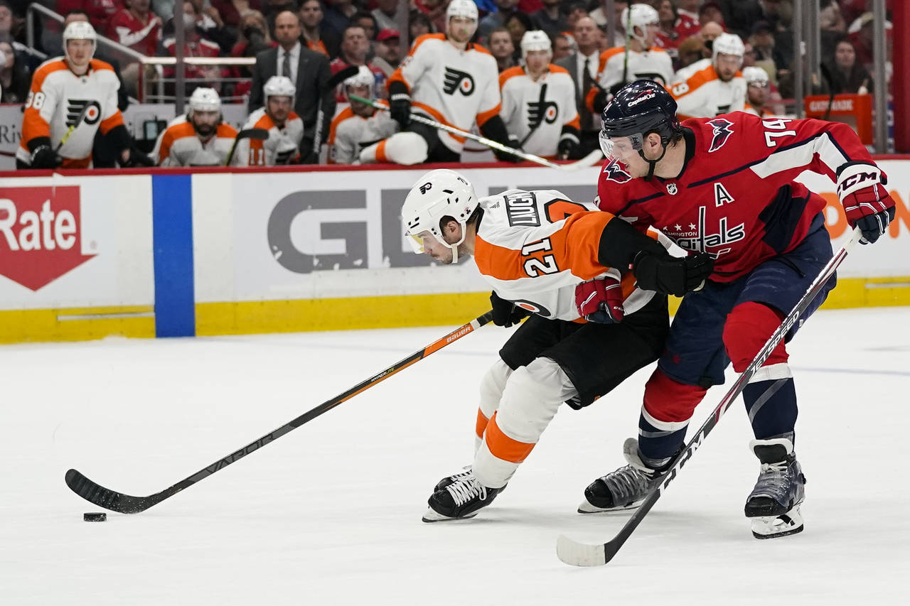Philadelphia Flyers center Scott Laughton (21) skates with the puck as Washington Capitals' John Ca...