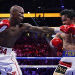 
              FILE - Yordenis Ugás, of Cuba, hits Manny Pacquiao, of the Philippines, in a welterweight championship boxing bout Aug. 21, 2021, in Las Vegas. Ugás faces Errol Spence Jr. in a unification bout Saturday, April 16. (AP Photo/John Locher, File)
            