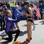 
              Alban Crook, of Iowa, gets down on one knee to propose to Karen Brophy, also of Iowa, at the finish line of the 126th Boston Marathon, Monday, April 18, 2022, in Boston. (AP Photo/Winslow Townson)
            