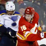 
              St. Louis Blues' Brayden Schenn, left, is checked by Calgary Flames' Michael Stone during second-period NHL hockey game action in Calgary, Alberta, Saturday, April 2, 2022. (Jeff McIntosh/The Canadian Press via AP)
            