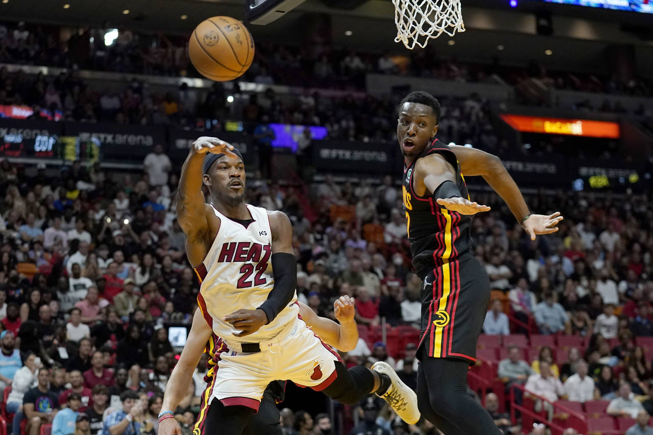 Miami Heat forward Jimmy Butler (22) passes the bal as Atlanta Hawks forward Onyeka Okongwu defends...