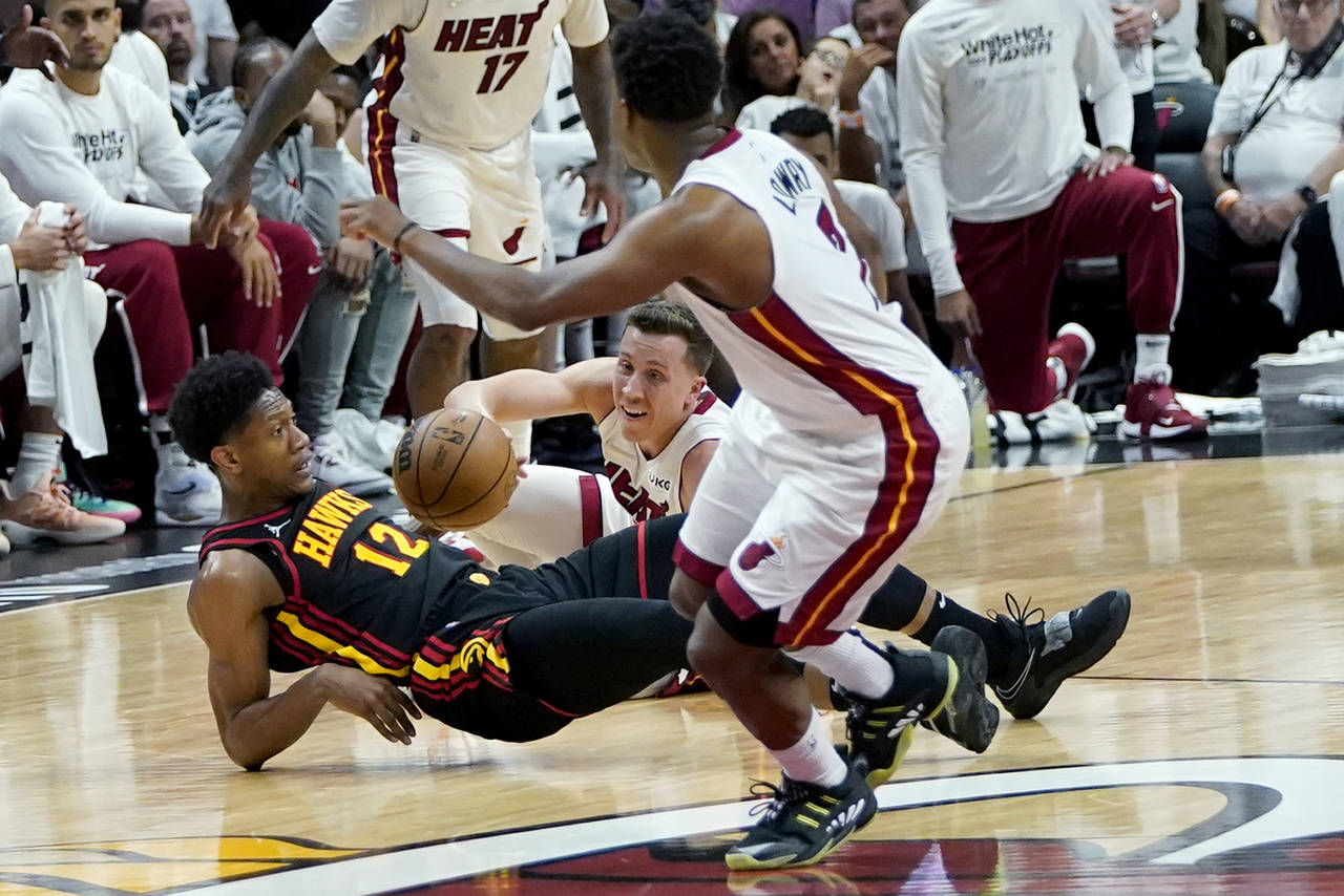 Atlanta Hawks forward De'Andre Hunter (12) and Miami Heat guard Duncan Robinson go for a loose ball...
