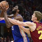 
              Philadelphia 76ers center Joel Embiid, left, is fouled while while going to the basket against Cleveland Cavaliers forward Lauri Markkanen in the second half of an NBA basketball game, Sunday, April 3, 2022, in Cleveland. (AP Photo/David Dermer)
            