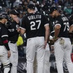 
              Chicago White Sox pitching coach Ethan Katz, second from left, talks with starting pitcher Lucas Giolito (27) during the sixth inning of a baseball game against the Los Angeles Angels in Chicago, Friday, April 29, 2022. (AP Photo/Nam Y. Huh)
            