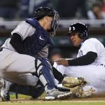 
              New York Yankees catcher Kyle Higashioka, left, tags Detroit Tigers' Jonathan Schoop out at home plate in the seventh inning of a baseball game in Detroit, Tuesday, April 19, 2022. (AP Photo/Paul Sancya)
            