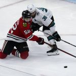 
              Chicago Blackhawks center Reese Johnson, left, and San Jose Sharks defenseman Mario Ferraro battle for the puck during the third period of an NHL hockey game in Chicago, Thursday, April 14, 2022. (AP Photo/Nam Y. Huh)
            