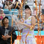 
              Iga Swiatek, right, of Poland, holds up her trophy after beating Naomi Osaka of Japan, left, 6-4, 6-0, during the women's singles finals of the Miami Open tennis tournament, Saturday, April 2, 2022, in Miami Gardens, Fla. (AP Photo/Wilfredo Lee)
            