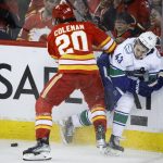 
              Vancouver Canucks defenceman Quinn Hughes, right, is checked by Calgary Flames center Blake Coleman during the second period of an NHL hockey game Saturday, April 23, 2022, in Calgary, Alberta. (Jeff McIntosh/The Canadian Press via AP)
            
