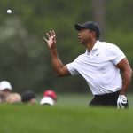
              Tiger Woods catches a golf ball from his caddie on the 12th tee box as he prepares to tee off during a practice round for the Masters at Augusta National Golf Club in Augusta, Ga., Wednesday, April 6, 2022. (Curtis Compton/Atlanta Journal-Constitution via AP)
            