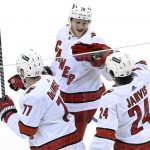 
              Carolina Hurricanes center Seth Jarvis (24) celebrates with Steven Lorentz (78) and Tony DeAngelo (77) after Jarvis scored the winning goal in overtime to defeat the New Jersey Devils 3-2 in an NHL hockey game Saturday, April 23, 2022, in Newark, N.J. (AP Photo/Bill Kostroun)
            