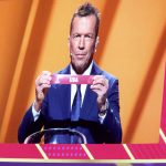 
              Former German soccer international and manager Lothar Matthaus is projected on a giant screen as he holds up the name of USA during the 2022 soccer World Cup draw at the Doha Exhibition and Convention Center in Doha, Qatar, Friday, April 1, 2022. (AP Photo/Hussein Sayed)
            