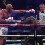 
              Britain's Tyson Fury, left, aims a blow at Britain's Dillian Whyte during their WBC heavyweight title boxing fight at Wembley Stadium in London, Saturday, April 23, 2022. (AP Photo/Ian Walton)
            